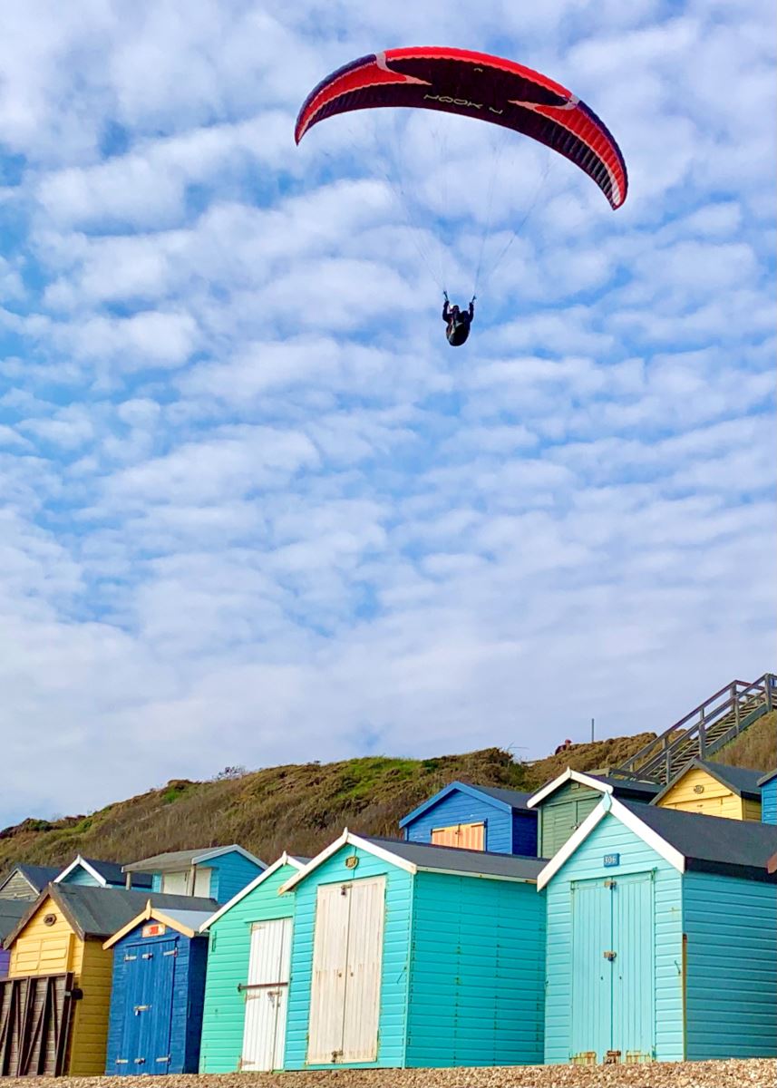 paraglider over the beach huts on Milford on Sea